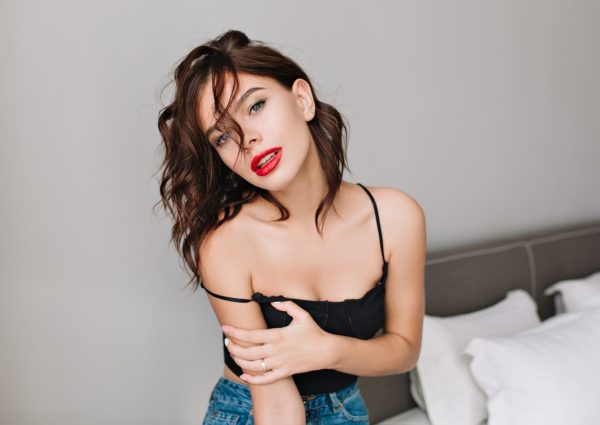 Portrait attractive girl with naked shoulders chilling in modern apartment. Fashionable brunette young model, red lips, relaxing time, fashion. Portrait attractive girl with naked shoulders chilling in modern apartment. Fashionable brunette young model, red lips, relaxing time, fashion